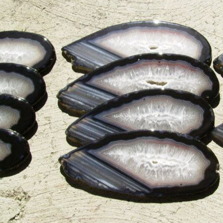Sliced black abalone arranged on a textured beige surface