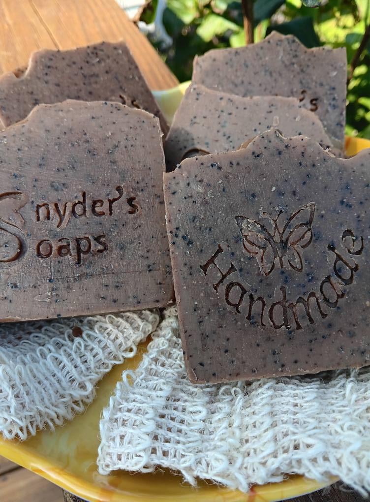 Handmade soap bars with 'Snyder's Soaps' branding on a yellow plate.