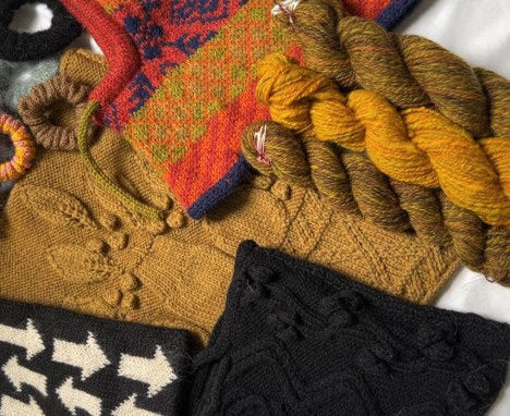 Collection of knitted items and yarn in various colors on a white background